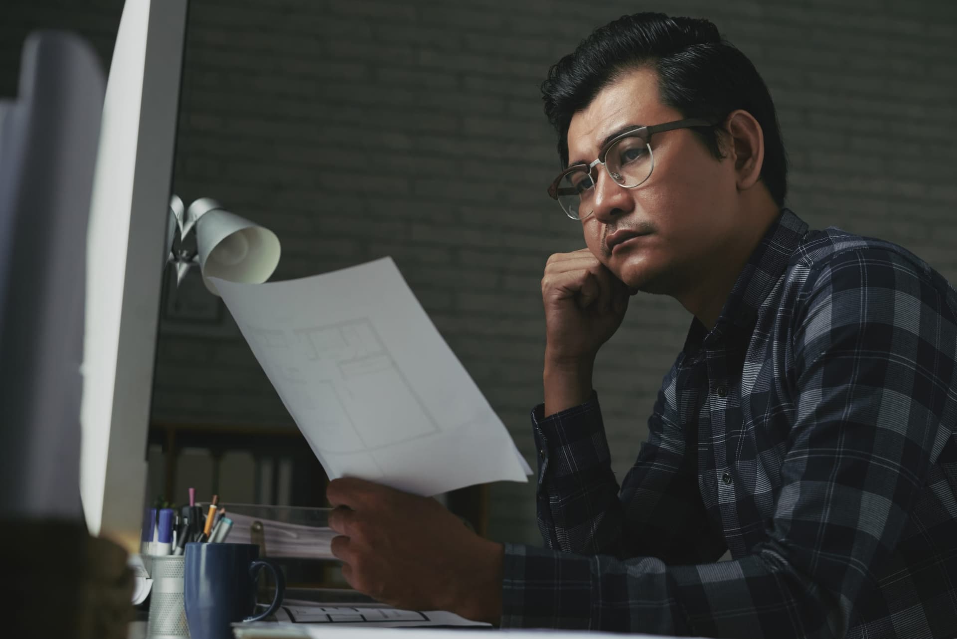Nhà thiết kế trầm ngâm nhìn bản vẽ in giấy, không biết lập trình viên sẽ hiểu ý đồ thế nào
